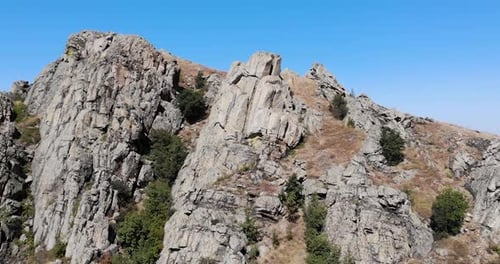 Formation rocheuse de granit dans la chaîne de montagnes Macin en Roumanie contre le ciel bleu. retrait aérien