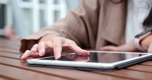 Frau benutzt Tablet-Computer im Café im Freien