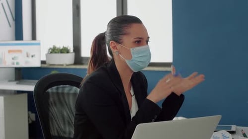 Woman Wearing Face Mask Speaking in an Office