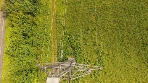 Electrical Tower Rising Above Green Field, Aerial View