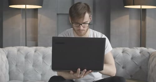Front View Portrait of Concentrated Brunette Man Working Online with Laptop. Handsome Millennial
