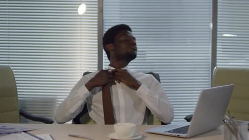 Tired Black Corporate Employee Working on Laptop Late at Night