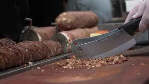 Cook Dicing Meat with Cleavers on Wood Surface