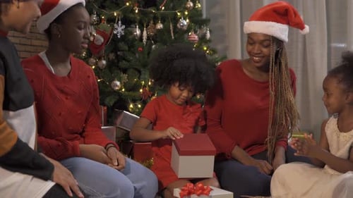African American black family, women and kid girl daughters sharing gifts on Merry Christmas