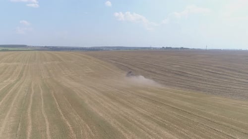 Aerial view of farm tractor plowing a field