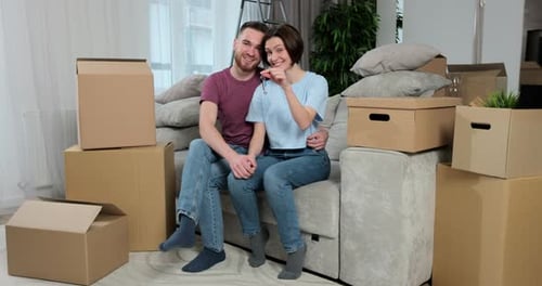 Smiling Couple Holding Keys in New Home