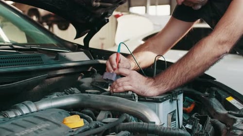 Repairman Working on Car Engine in Garage