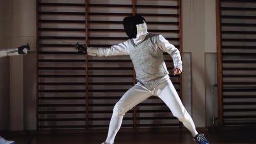 Man In Fencing Gear And Mask Duelling With OffScreen Opponent