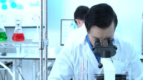 Scientist looking through microscope