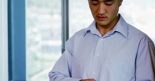 Young Adult Uses Tablet in Urban Office