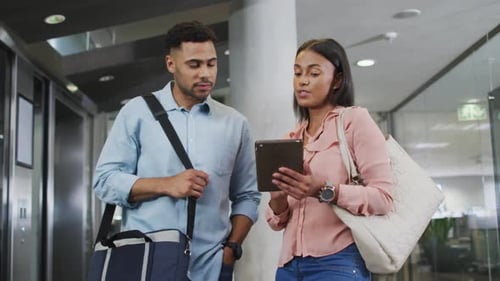 Business Professionals Discussing on Tablet in Office Building