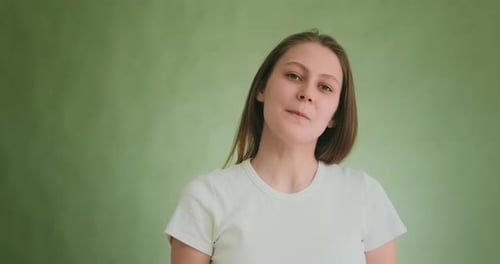 Attractive Woman with Blonde Hair Poses for Camera on Green
