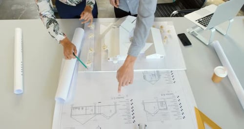 Architectural Designers Reviewing Building Model and Blueprints