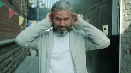 Slow Motion of Attractive Man Touching Hair Crossing Arms and Looking at Camera with Happy Face