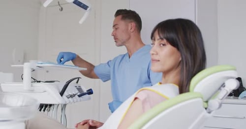 Porträt einer lächelnden Patientin mit einem kaukasischen männlichen Zahnarzt in einer modernen Zahnklinik