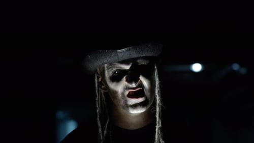 Creepy Man with Skeleton Makeup Appearing From Darkness When Light Falls on Him, Making Faces