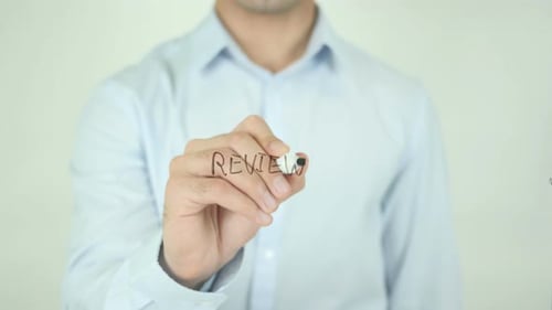 Man Writing Review on Transparent Surface