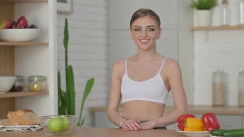 Smiling Woman in Kitchen with Healthy Food