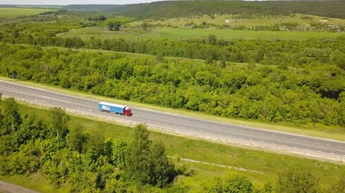 Truck Driving on Highway Through Rural Landscape