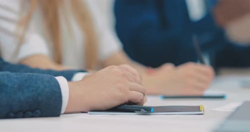 Professionals Attending Corporate Meeting Taking Notes