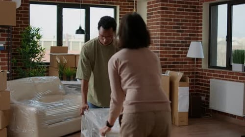 Couple Moves Furniture into New Apartment