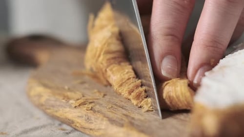 Extreme Close Up Woman Chef Cuts Croissant