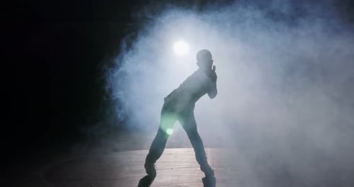 Young Dancer Performing in Smoky, Dimly Lit Room