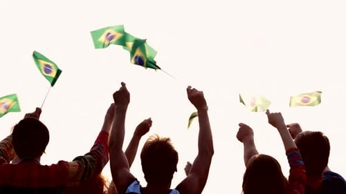 Pessoas agitando bandeiras brasileiras ao ar livre