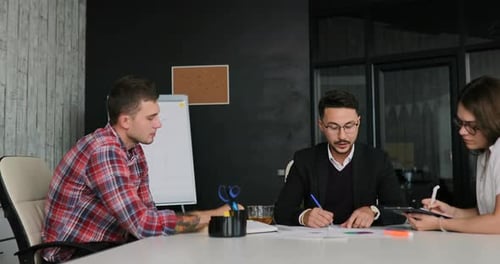 Creative Team of a Business Meeting in a Modern Starting Office Discussing Ideas for the Development