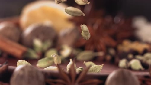Fragrant Spices Falling Into Wooden Bowl