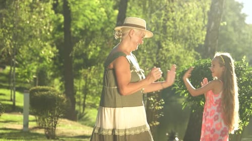 Grandmother Playing with Granddaughter Outdoors.