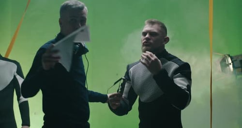 Men Discuss Project on Green Screen Film Set