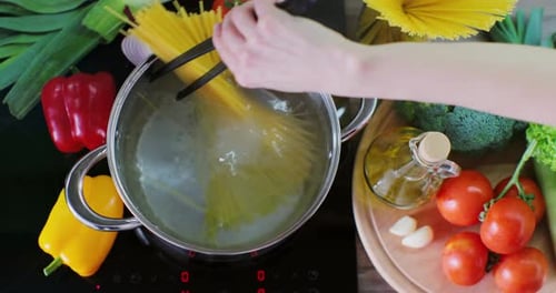 Cooking Spaghetti Noodles in Boiling Water with Vegetables