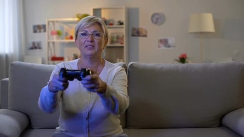 Enthusiastic Mature Woman Plays Video Game at Home