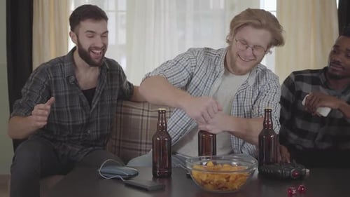 Young Adults Opening Beer and Eating Chips