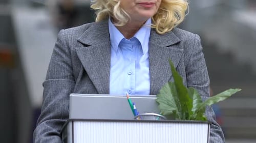 Femme âgée déprimée tenant une boîte avec des effets personnels, des suppressions d'emplois, une pension