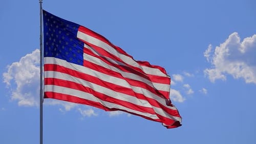USA Flag Waving Proudly Against Blue Sky