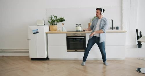 Man Dancing Joyfully in Bright Modern Kitchen