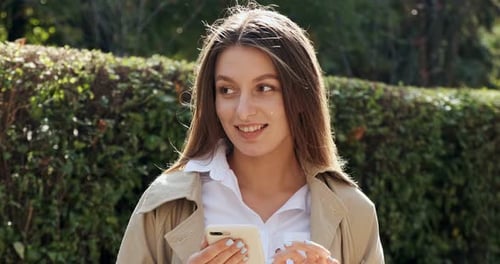 Smiling Woman Using Mobile Phone Outdoors