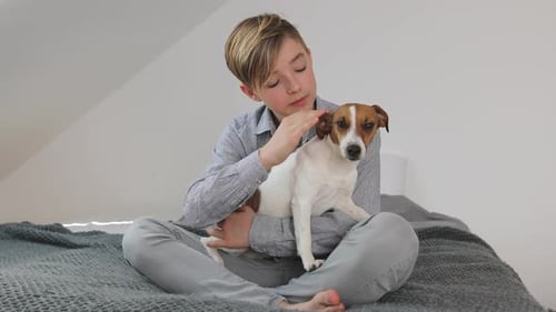 Boy Cuddling with His Dog Inside Bedroom