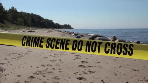 Crime Scene Tape Across a Sandy Beach