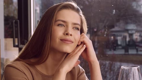 Nahaufnahmeporträt einer jungen glücklichen Frau, die ihren Freund bei einem angenehmen Date im Café betrachtet