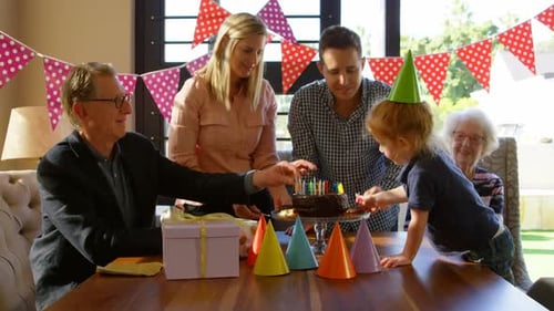 Family Celebrating Child's Birthday With Cake