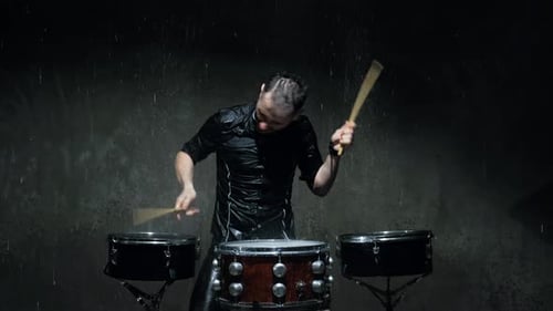 Enthusiastic Drummer Playing Drums in the Rain