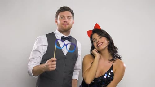 Couple with Party Props Having Fun and Posing