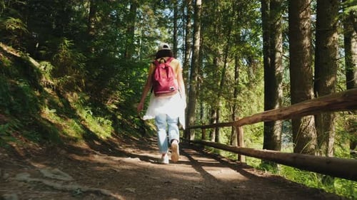 Girl Walks Along a Trail in a Mountain Forest