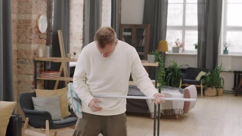 Man Dances and Sings Pretending Mop is Guitar