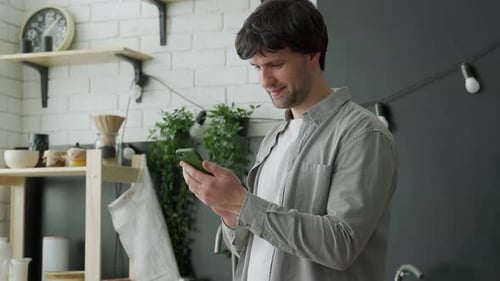 Young Adult Man Using Mobile Phone Indoors