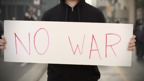 Unbekannter Aktivist hält ein Plakat mit NO WAR-Text