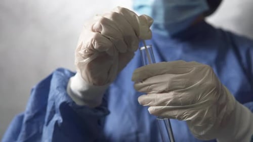 PCR-Test im Labor. Der Arzt untersucht die entnommene Probe, um Abstriche für COVID-19 zu sammeln.